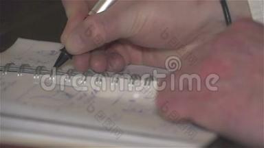 男人用钢笔的手在笔记<strong>本</strong>上做了记录。